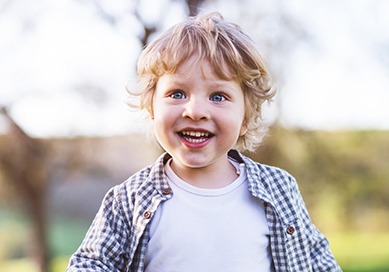 Little boy smiling outside